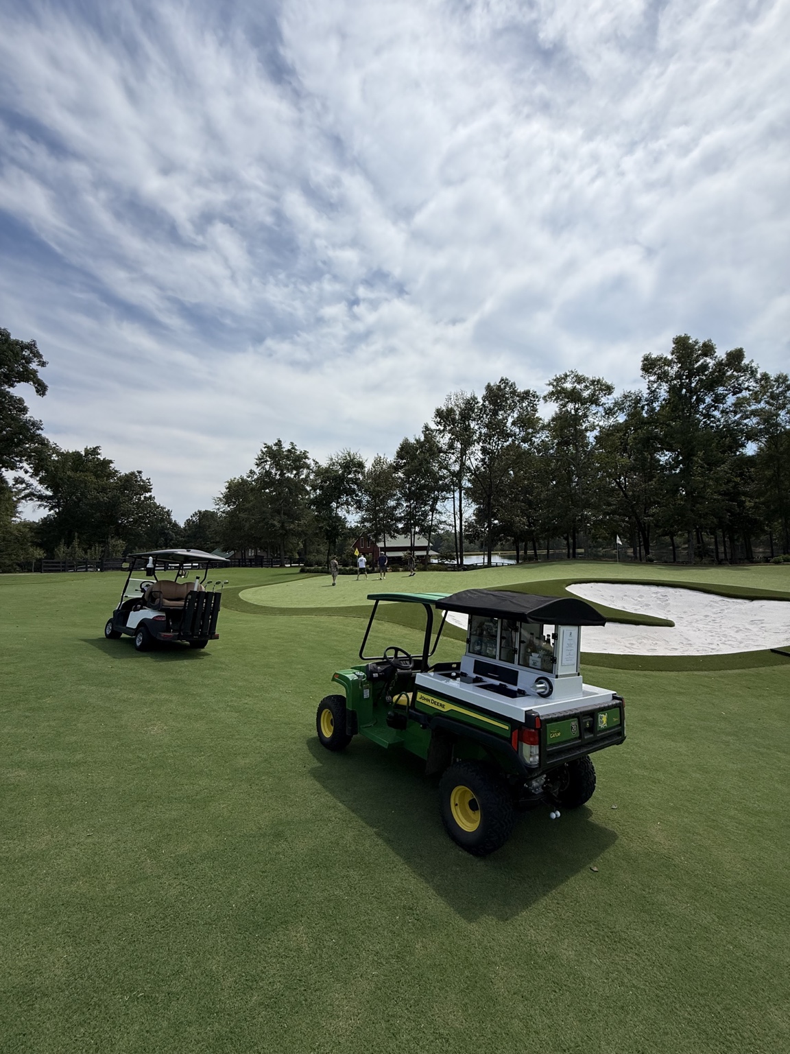Golf carts beside the green and bunker at The Goat Track