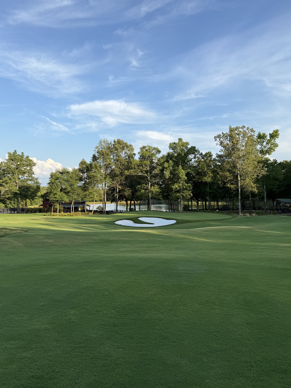 Wide view of The Goat Track green, bunkers and pond
